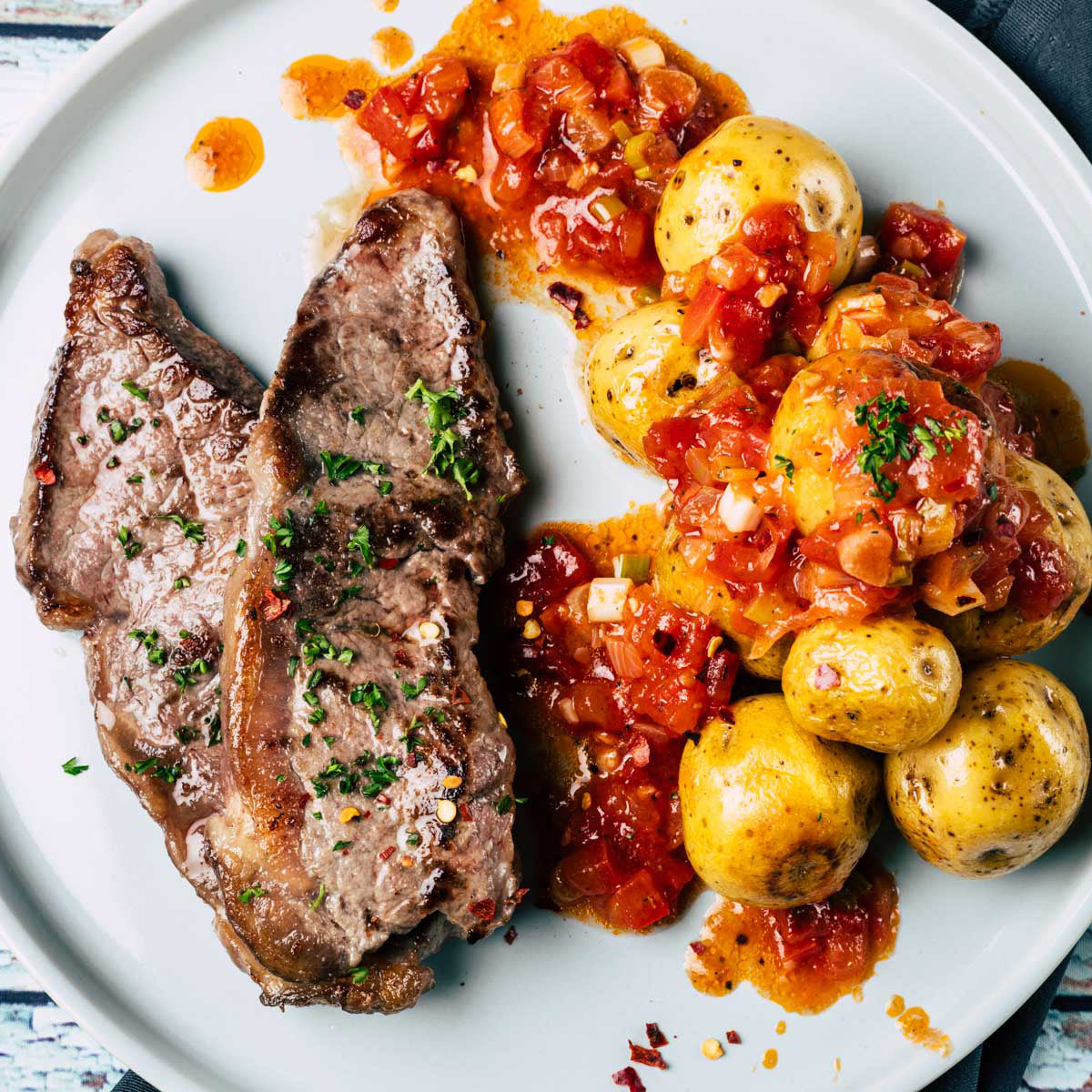 Churrasco a la colombiana asado con hogao y papas criollas acompañados de zanahoria y espinaca